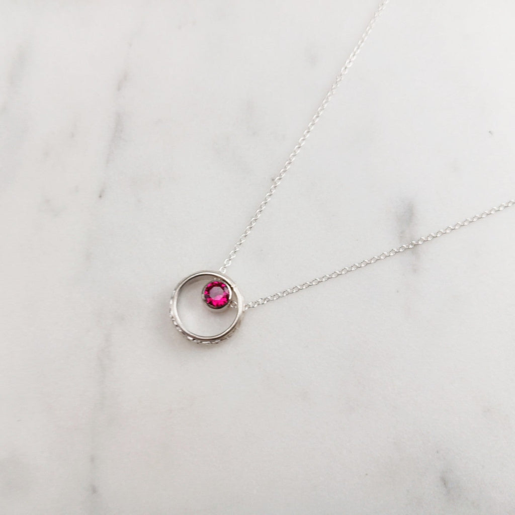 A bohemian-style, vintage-inspired sterling silver ruby hoop necklace