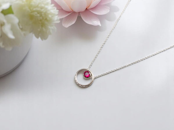 A bohemian-style, vintage-inspired sterling silver ruby hoop necklace