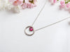A bohemian-style, vintage-inspired sterling silver ruby hoop necklace
