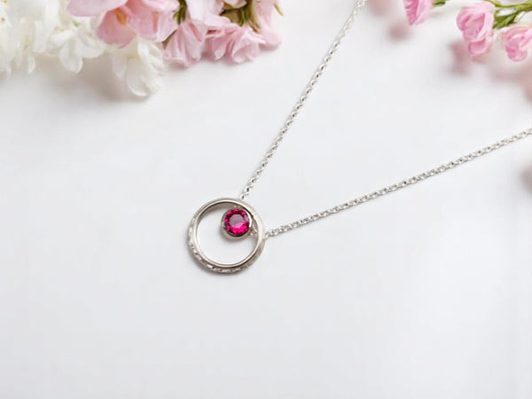 A bohemian-style, vintage-inspired sterling silver ruby hoop necklace